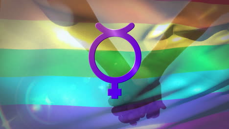 símbolo no binario femenino con cuernos contra una bandera arco iris