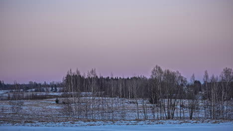 Toma-Estática-De-La-Luna-Se-Pone-Justo-Cuando-El-Sol-Sale-En-El-Fondo-Al-Amanecer-En-Un-Lapso-De-Tiempo-Sobre-El-Paisaje-Rural