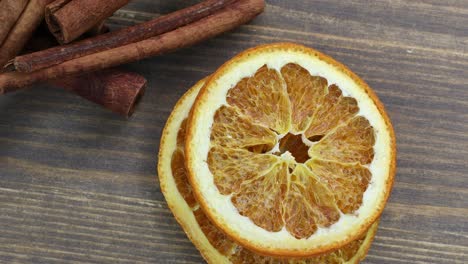 dried oranges with cinnamon on a wooden background