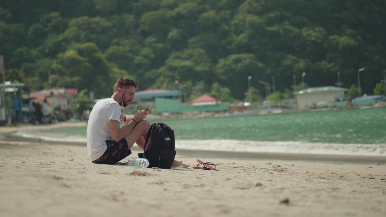 여행 가방을 들고 해변에 앉아 필리핀 엘니도의 유명한 열대 섬을 즐기는 관광객 - 여름 휴가에 완벽함 - 와이드 샷