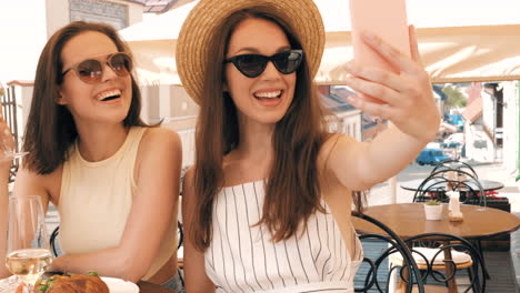 friends enjoying a cafe lunch and taking a selfie