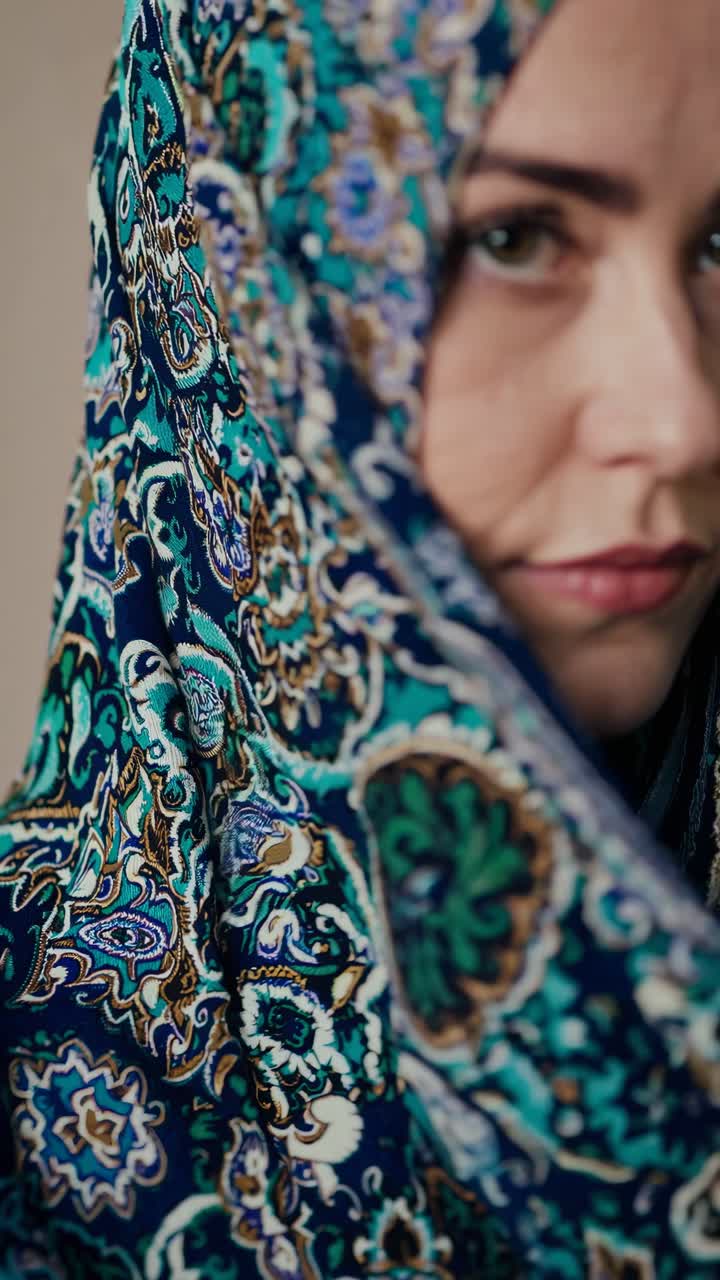Close-up portrait of a woman in a patterned headscarf, capturing a thoughtful expression