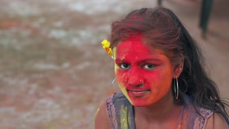 indian women close-up of face smeared with bright holi colors