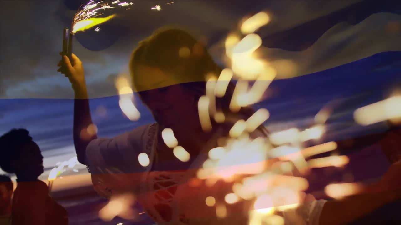 animación de ondear la bandera de colombia sobre un grupo de amigos con chispas divirtiéndose en la playa