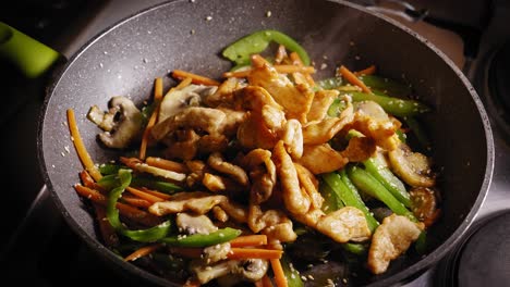 adding chicken breast pieces to frying pan, stirring in pan, asian food