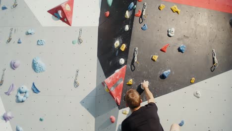 hombre bouldering en la pared de escalada