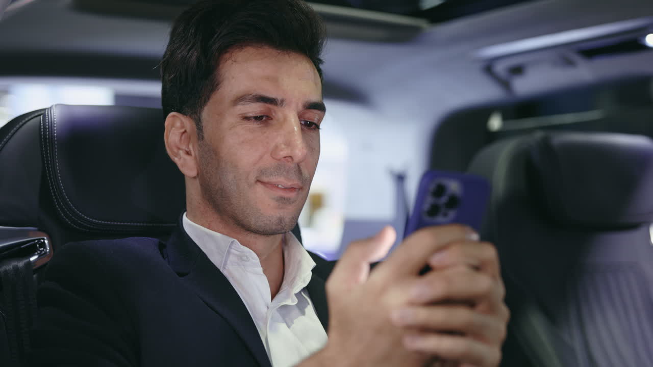 Businessman using a smartphone in a car