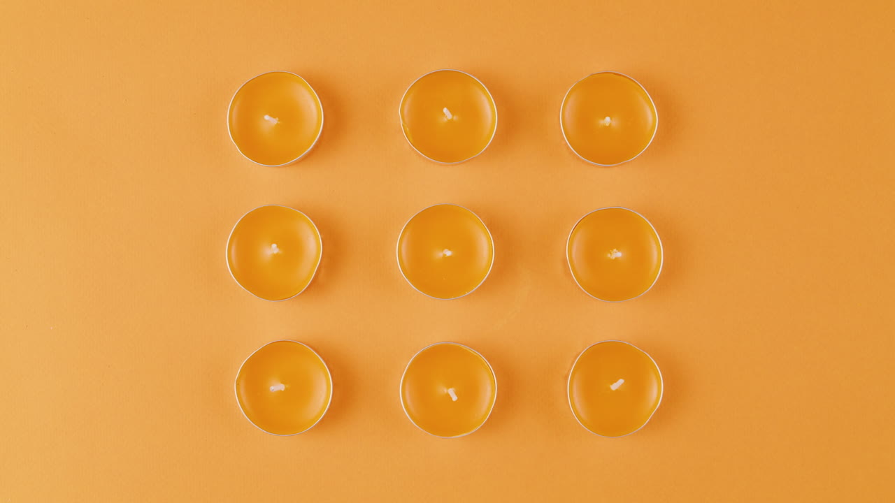 Tea Light Candles on Orange Background