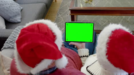 senior caucasian couple having christmas tablet video call with green screen, slow motion