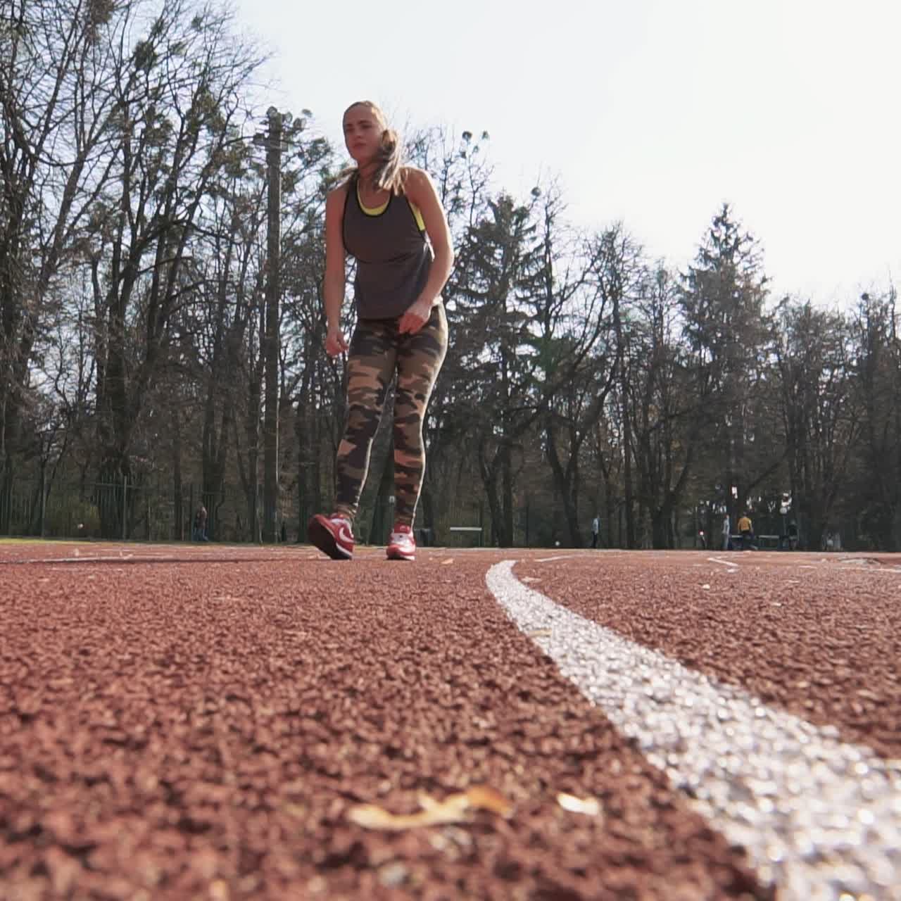 Young woman is stretching her legs after running. Summer outdoors training.