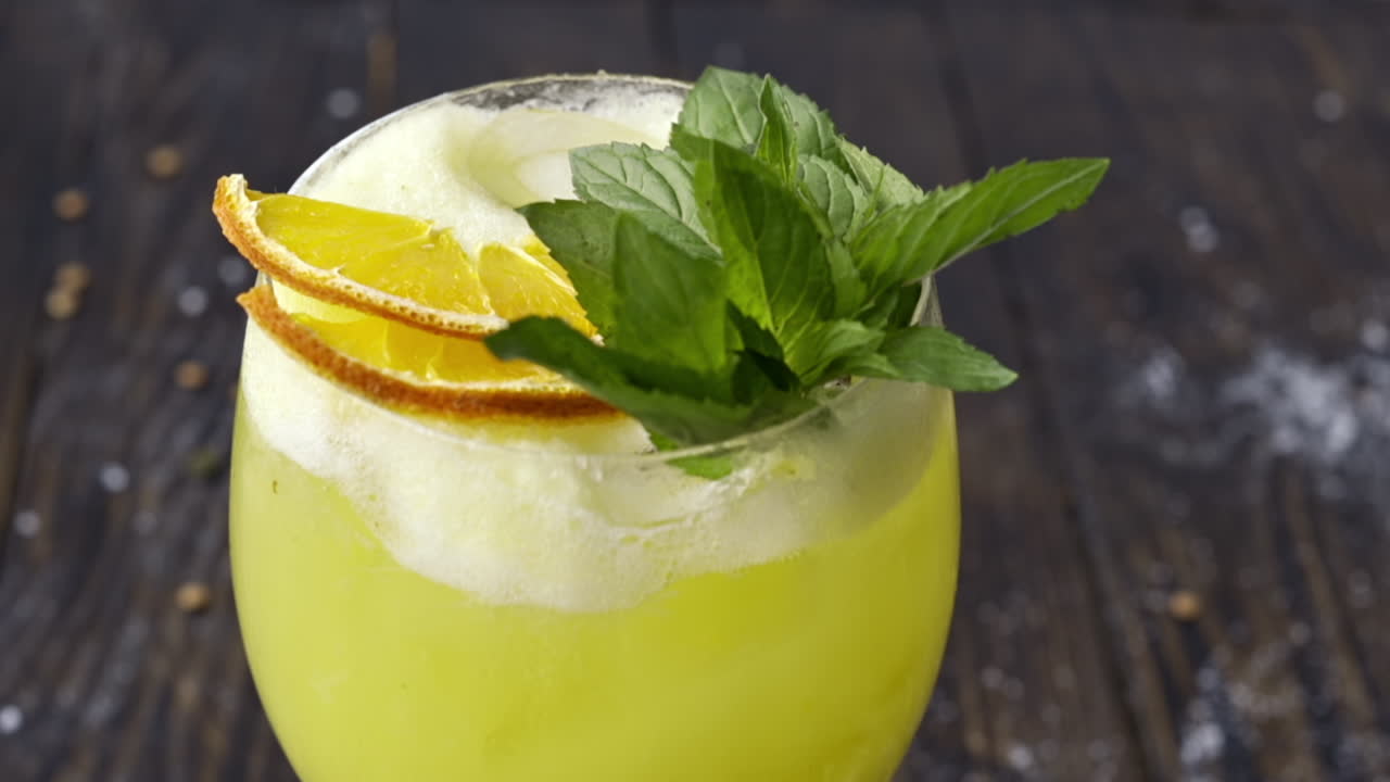 Lasillinen keltaista mintulla maustettua limonadia puupinnalla