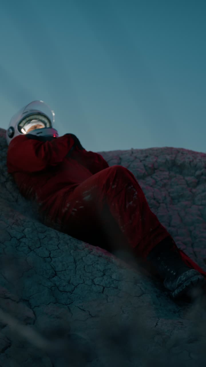 astronauta frío y solitario en una montaña por la noche con casco preparándose para dormir