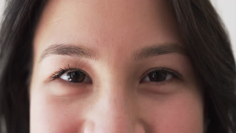 Portrait-close-up-of-happy-biracial-woman-smiling-at-home,-slow-motion