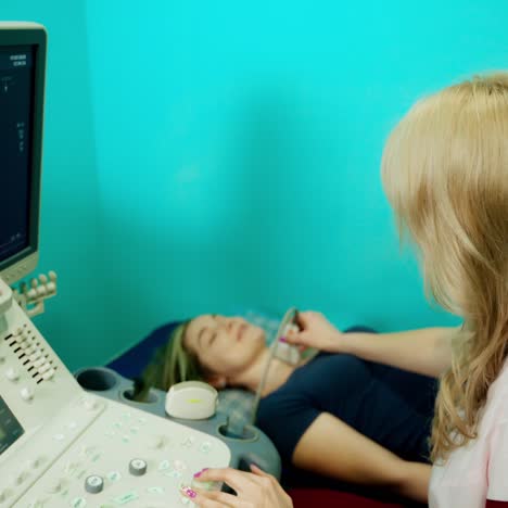 doctor checkup and scanning thyroid gland. ?octor examining girl throat with special equipment