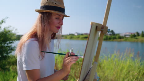 woman painting outdoors by a lake