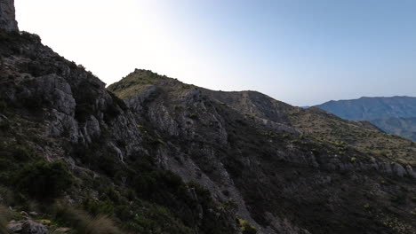 4k-Shot-of-a-large-mountain-ridge-with-tourists-walking-on-it-at-La-Concha,-Marbella,-Spain