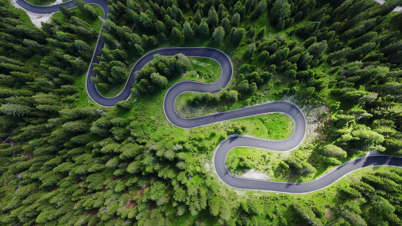 Drone vertical ascent of Passo Giau, Winding green alpine road, vibrant sunlight