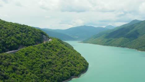 impresionante toma aérea del lago turquesa del valle de la montaña rodeado de un bosque exuberante
