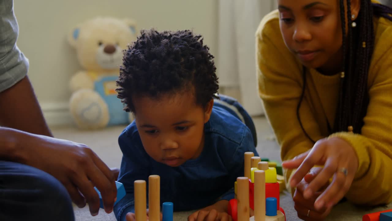 Close-up of young black parents and son playing with toys in a comfortable home 4k