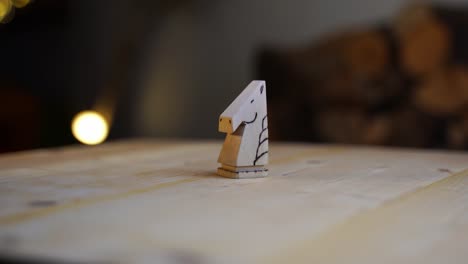 wooden carved chess piece, horse knight on wooden board rotates against dark background