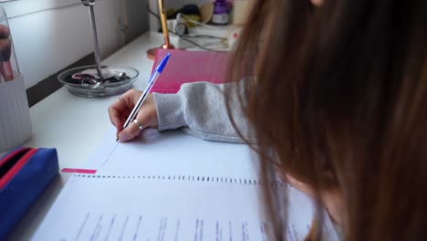 static shot of unrecognizable girl studying and taking notes, 4k