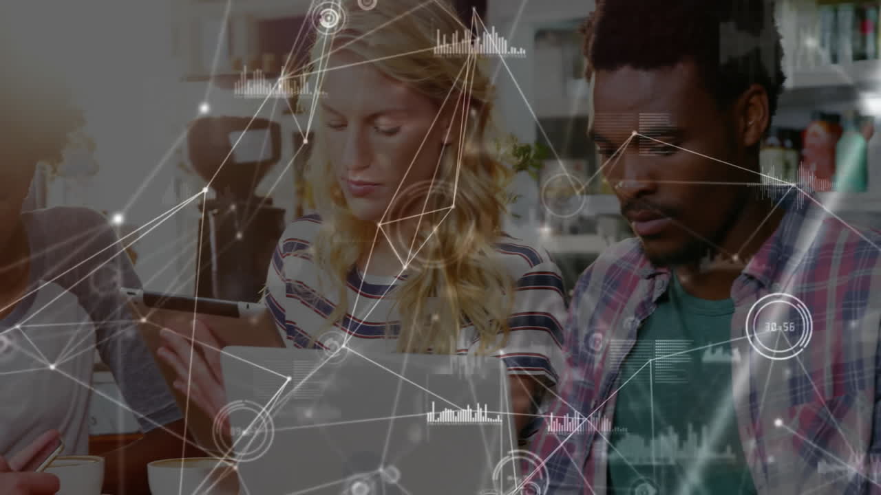 Group collaborating at café, viewing animated graphs for technology pitch on laptops and tablet