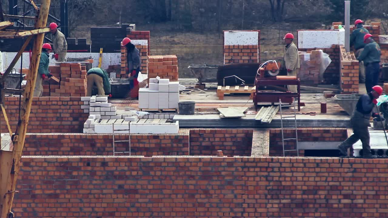 Close Up of Builders with a Red Helmets on a Building Under Construction. Time Lapse