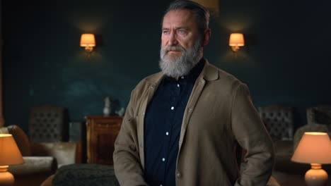 portrait handsome senior man standing in luxury cabinet. confident old man