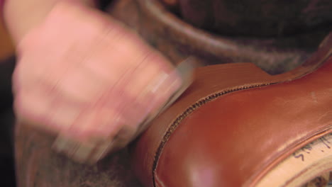 bespoke shoemaker staining and polishing leather of shoe