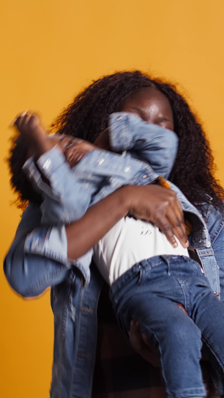 Madre afroamericana felice che gioca e ride con suo figlio