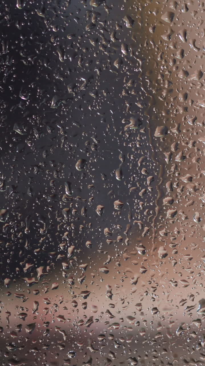 Transparent misted glass booth with water drops against blurred view of woman washing feet in shower daily routine slow motion closeup