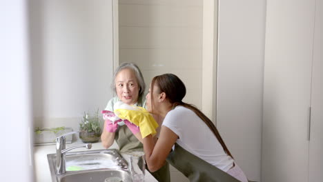 washing dishes together, asian grandmother and granddaughter bonding time in kitchen