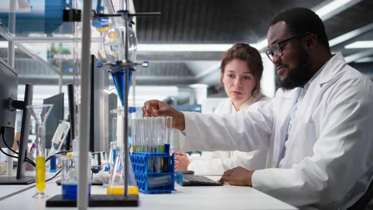 Vertical video Team of analytical chemists work together, using laboratory solutions