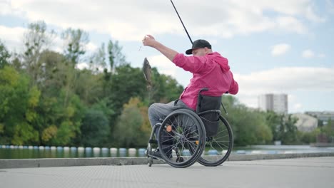 person with a physical disability who uses wheelchair fishing from fishing pier