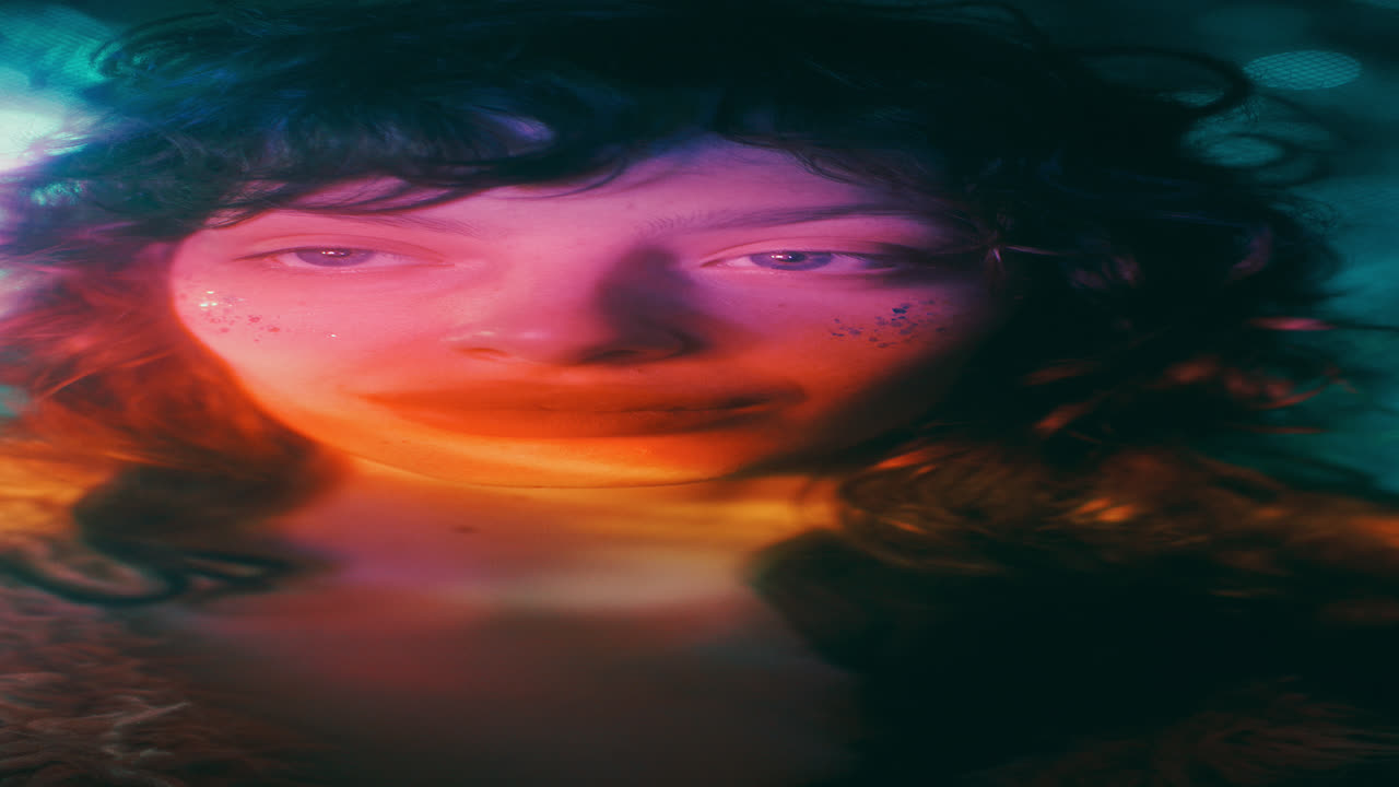 Portrait of Girl with Sparking Glitter Cheeks under Colorful Lights