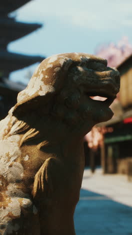 close-up of a stone lion statue in front of a japanese temple