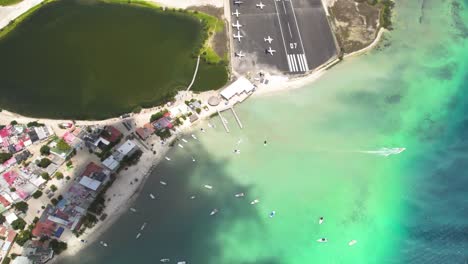 Los-roques-archipelago-with-boats-and-clear-turquoise-waters,-tilt-up-shot,-aerial-view