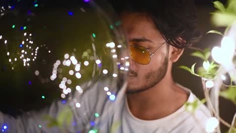 young asian homosexual gay male decorates place with colorful party lights for celebration of diwali, christmas or new year