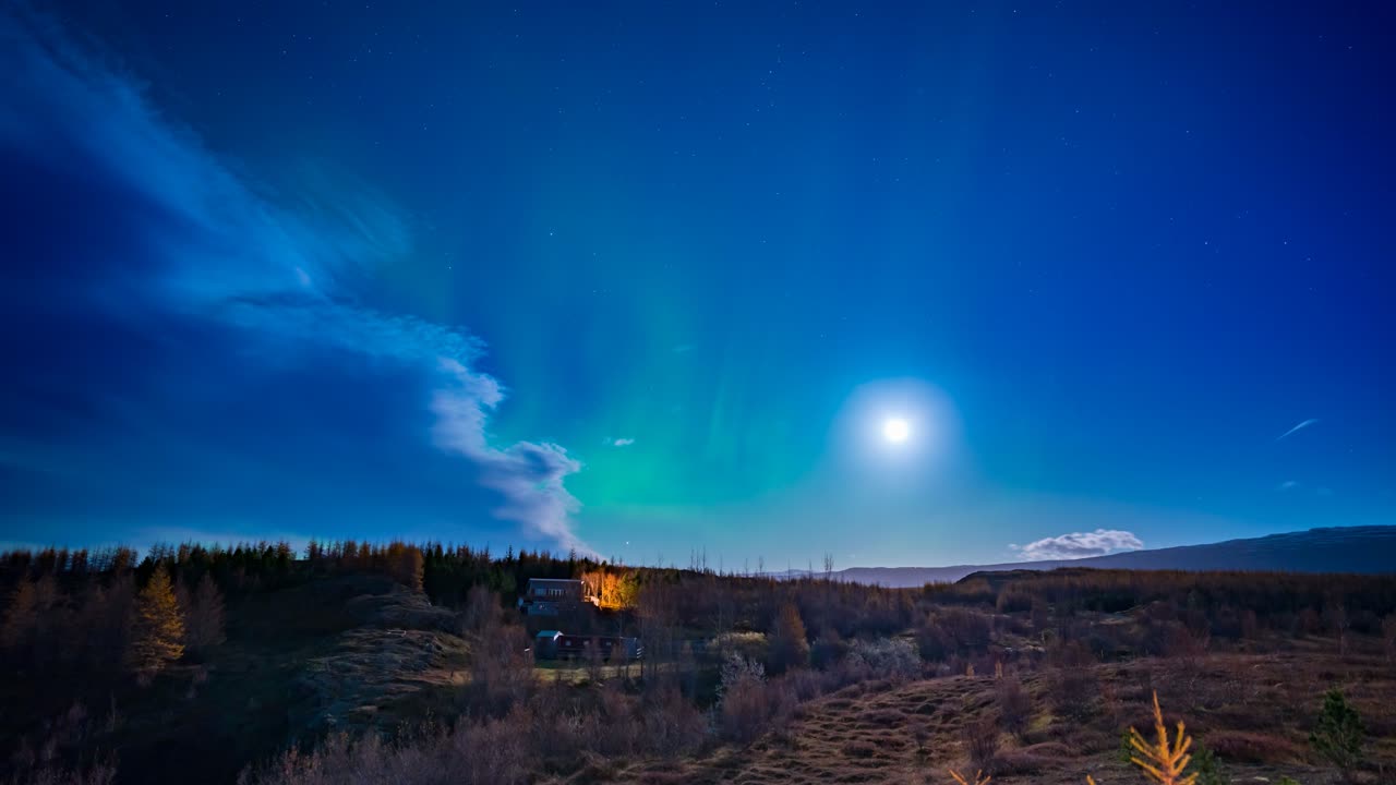 Northern lights, aurora borealis time lapse during a full moon near Egilsstadir, Iceland