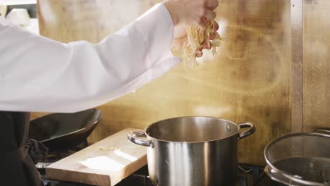 chef putting the pasta in boiling water