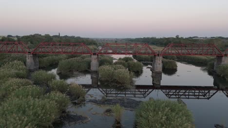 Slow-rising-drone-shot-of-old-railway-bridge-crossing-Komati-River-early-morning,-South-Africa