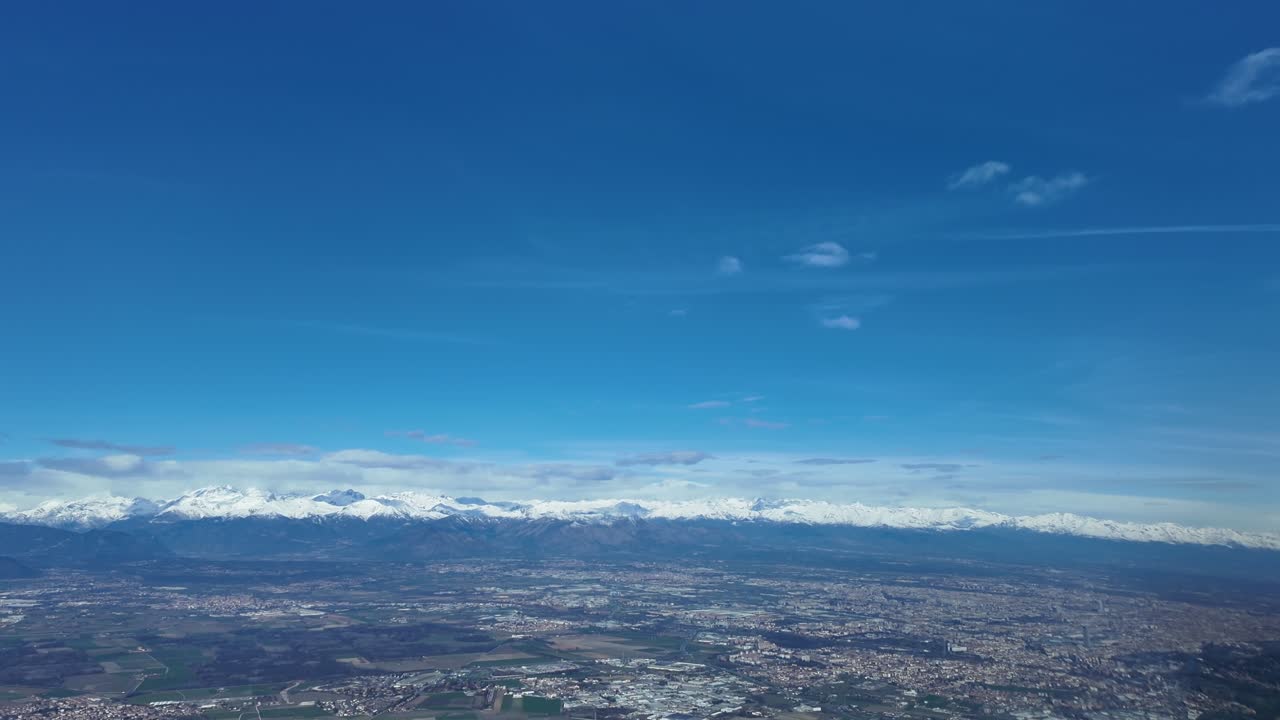 Pemandangan imersif dari sudut pandang pilot dalam pendekatan akhir ke bandara Turin (TRN) pada hari musim dingin dengan pegunungan Alpen yang tertutup salju di latar belakang
