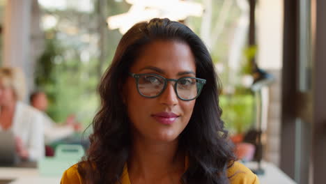 Portrait-Of-Mature-Businesswoman-Wearing-Glasses-Working-In-Office-At-Desk