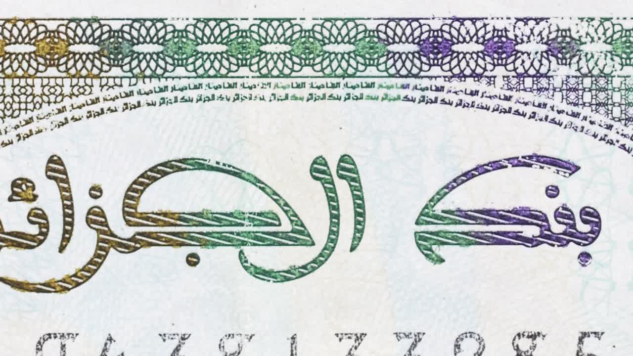 Macro pan across an Algerian banknote, revealing “Bank of Algeria” Arabic text