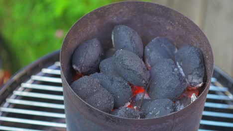 hot glowing coals laying on top of each other in a metal container