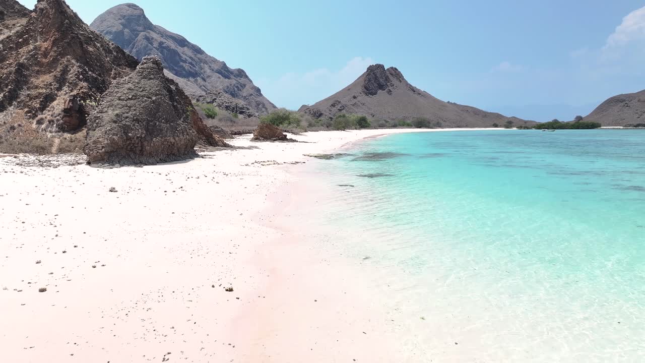 Lone traveler on pristine Pink Beach, Komodo, Indonesia. Aerial, travelling, adventure.