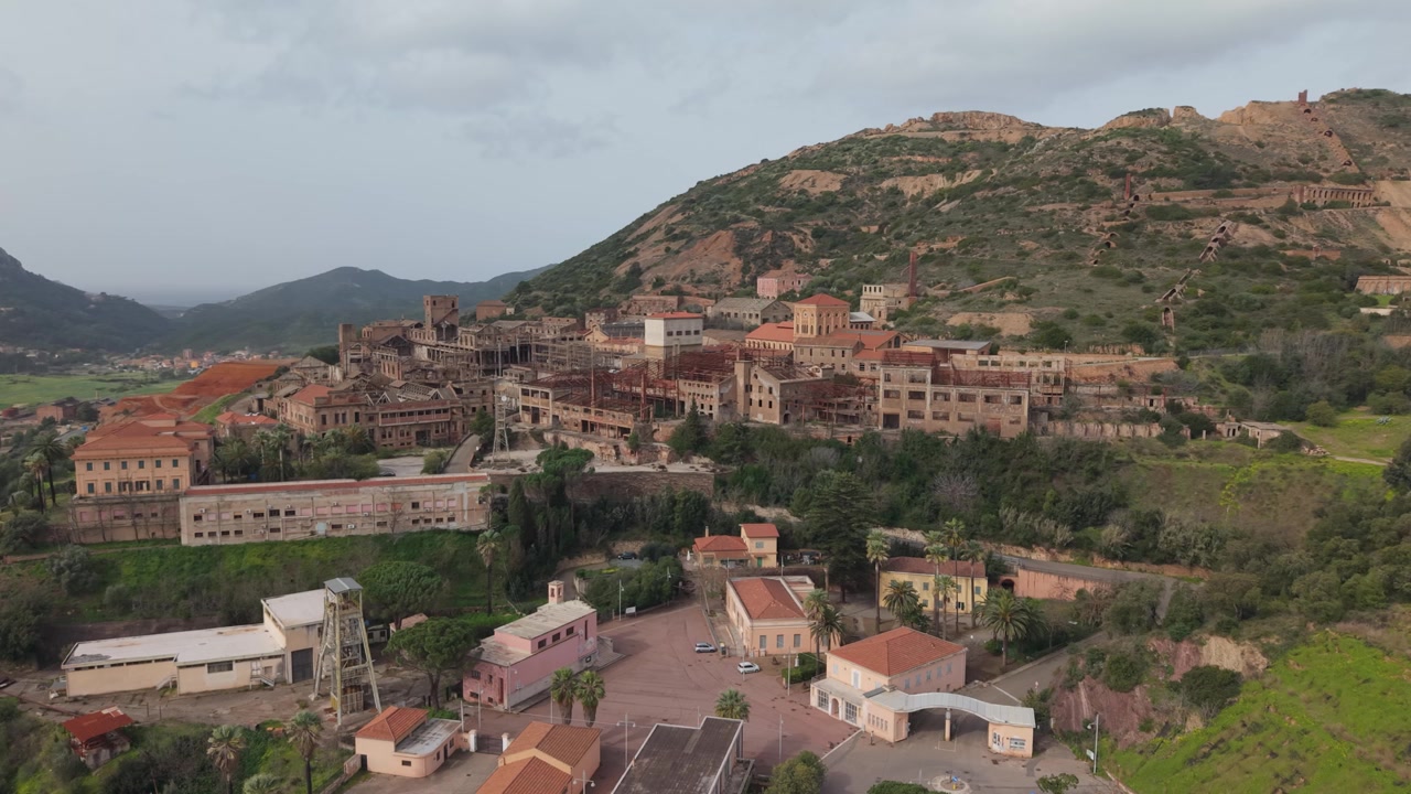Restos industriales y el paisaje accidentado del antiguo sitio minero de Monteponi cerca de Iglesias en Cerdeña, Italia - Toma de dron.