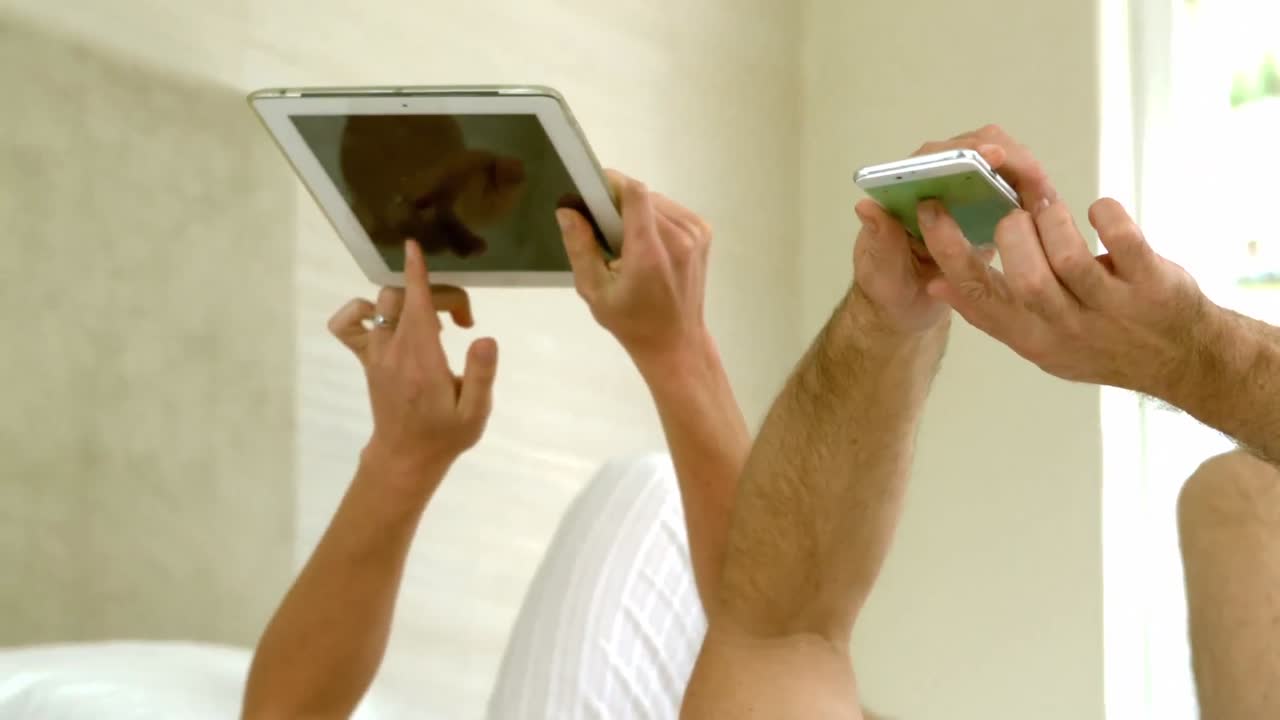 pareja linda usando tableta y teléfono inteligente