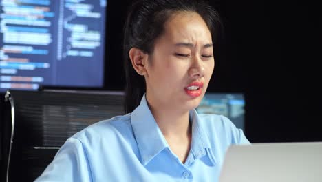 다중 모니터를 사용하여 노트북으로 코드를 작성하는 동안 허리 통증이있는 아시아 여성 프로그래머의 클로즈업은 사무실의 터미널 창 데스크에서 데이터베이스를 보여줍니다.