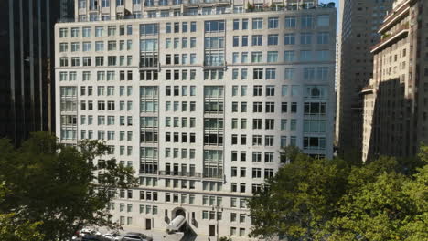 Elevated-aerial-of-a-flock-of-birds-in-front-of-apartments-in-the-Central-park,-NY